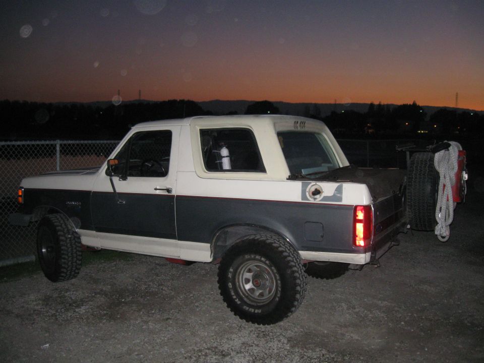 Two-tone Ford Bronco, rear quarter view, with spare tire on back