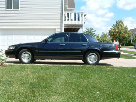 1999 Mercury Grand Marquis - A dark blue 1999 Mercury Grand Marquis is parked in a driveway on a sunny day.