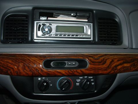 1999 Mercury Grand Marquis - Interior view of a car's dashboard, showing the center console with climate controls and an aftermarket stereo system.