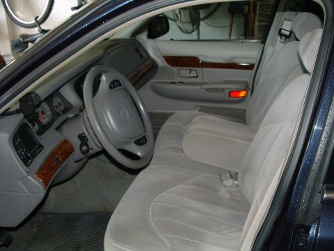 1999 Mercury Grand Marquis - The interior of a 1999 Mercury Grand Marquis is shown, cloth seats and wood trim accents.