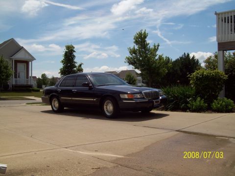 1999 Mercury Grand Marquis - This Mercury Grand Marquis is parked in a suburban driveway under a partly cloudy sky.