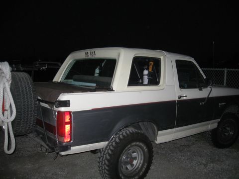 1991 Ford Bronco - This 1991 Ford Bronco is seen from a rear three-quarter angle at night, with a spare tire on the back.