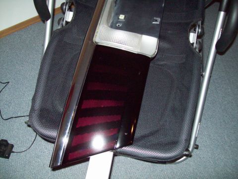 1999 Mercury Grand Marquis - A car tail light assembly with a dark red lens and chrome trim is shown resting on a chair.