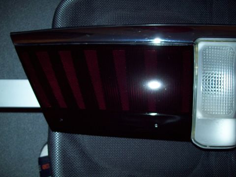1999 Mercury Grand Marquis - Close-up of a car's rear taillight assembly, showing the red lens and clear reverse light.