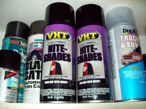 1999 Mercury Grand Marquis - A collection of automotive spray paint cans are neatly arranged on a shelf, ready for use.