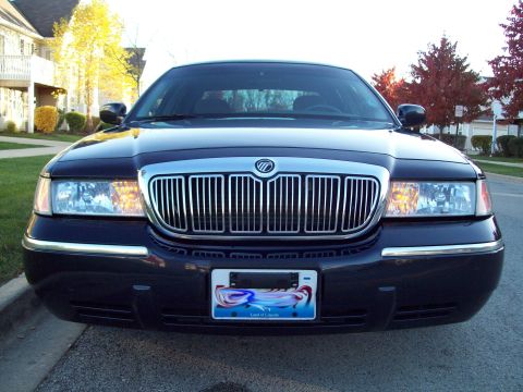 1999 Mercury Grand Marquis - Front view of a dark blue Mercury Grand Marquis with a chrome grille and a "Land of Lincoln" license plate.