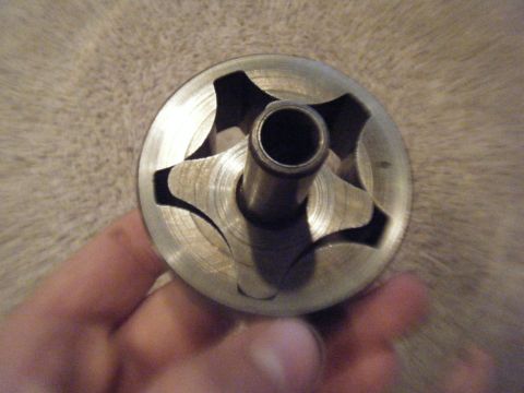 1979 Ford Bronco - Close-up of a metal oil pump rotor, showing its internal star-shaped vanes and central shaft.