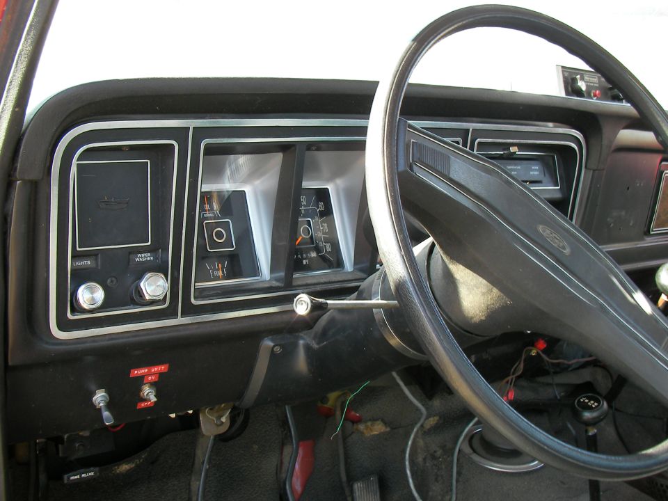 Dashboard of a 1979 Ford F-350, showing the instrument cluster, steering wheel, and floor shifter