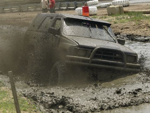 1989 Jeep Cherokee - A 1989 Jeep Cherokee navigates a muddy track, kicking up a large spray of water and dirt.