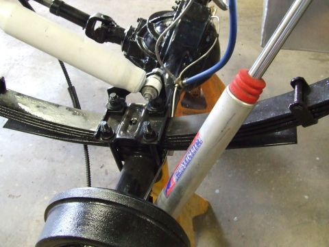 1967 Ford Bronco - Close-up view of a vehicle's rear axle assembly, leaf springs and a shock absorber.