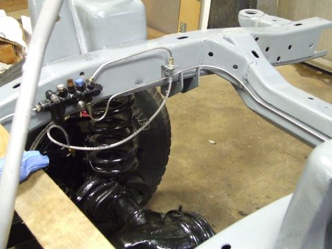 1967 Ford Bronco - Close-up view of brake lines and suspension components during a vehicle restoration project.