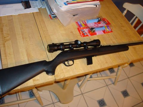 1977 Ford F-100 - A rifle with a scope rests on a table, accompanied by PEZ candy dispensers and various documents.