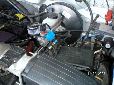 1996 Ford Bronco - Spout connector may hang down or be buried inside of a large wiring loom but should be in this area, Under driver side hood hinge.