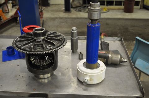 1996 Ford Bronco - Differential and bearing puller tool set up on a metal workbench with an impact wrench in the background.