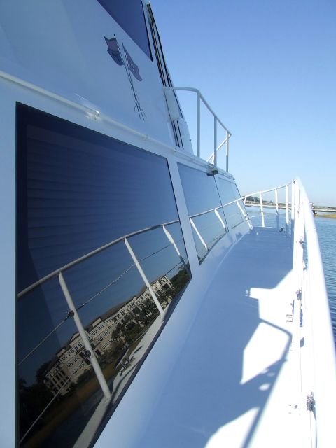 1976 Ford F-150 - View from the deck of a white boat, showing the windows and the reflection of buildings on the water.