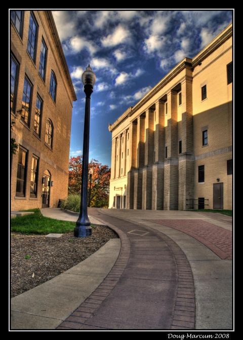 1996 Ford Bronco - A street scene shows two buildings and a lamppost on a curved walkway under a dramatic sky.