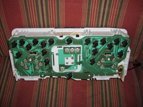 1993 Ford Crown Victoria - The rear of a vehicle's instrument cluster reveals its intricate green circuit board and numerous electrical components.