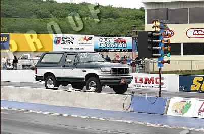 1995 Ford Bronco - A two-tone Ford Bronco sits on a drag strip, awaiting the start of a race.