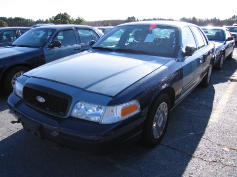 2001 Ford Crown Victoria - This 2001 Ford Crown Victoria sedan is parked in a lot with other vehicles.
