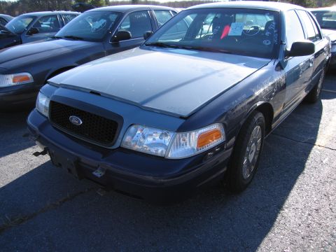 2001 Ford Crown Victoria - Front view of a 2001 Ford Crown Victoria, parked outdoors with another vehicle nearby.