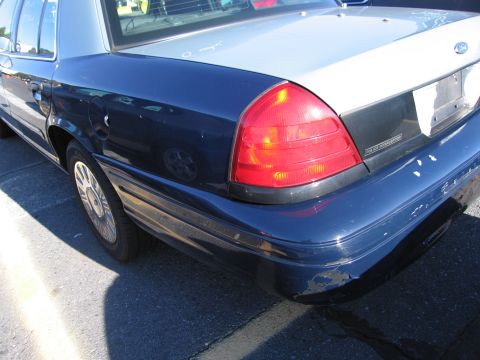 2001 Ford Crown Victoria - The rear of a Ford Crown Victoria Police Interceptor, showing its distinctive two-tone paint scheme and police badging.