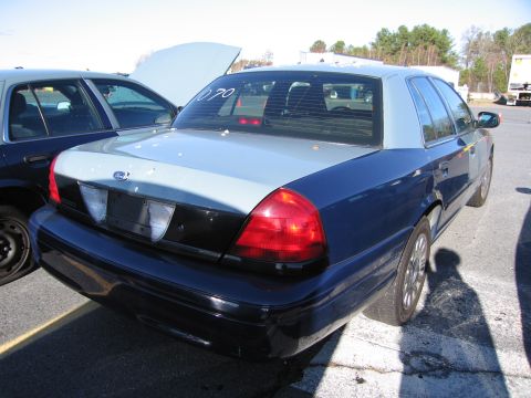 2001 Ford Crown Victoria - Rear view of a two-tone 2001 Ford Crown Victoria parked next to another vehicle.