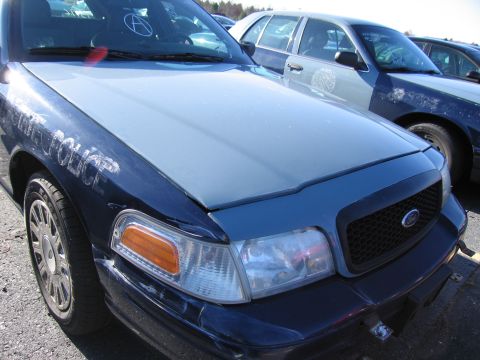 2001 Ford Crown Victoria - Ford Crown Victoria police car, likely from the early 2000s, parked next to another similar vehicle.