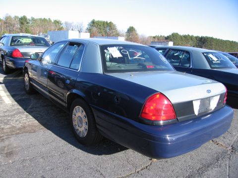 2001 Ford Crown Victoria - This 2001 Ford Crown Victoria sedan is seen from the rear, a two-tone blue and silver paint scheme.