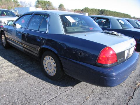 2001 Ford Crown Victoria - A dark blue and light blue 2001 Ford Crown Victoria is parked in a lot with other vehicles.