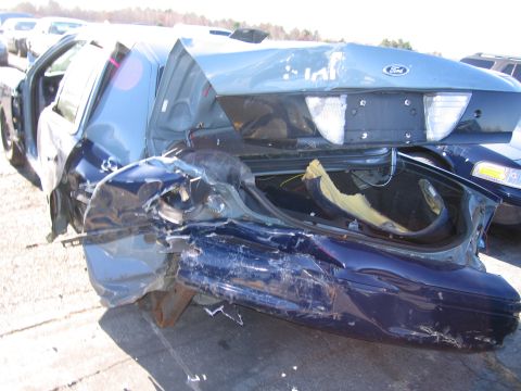 2001 Ford Crown Victoria - This 2001 Ford Crown Victoria sustained significant rear-end damage, with the trunk open and interior components exposed.