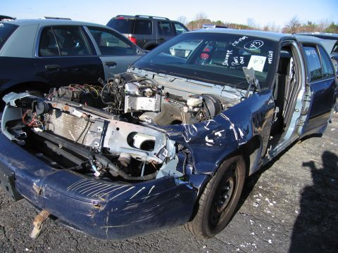 2001 Ford Crown Victoria - This damaged sedan has its front end dismantled, revealing the engine and radiator components.