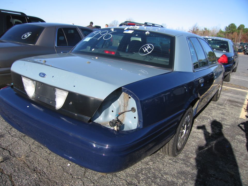 Dark blue and light blue Ford Crown Victoria with missing taillight and '1996' written on rear window