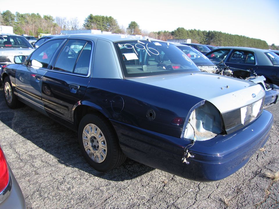 Rear view of a dark blue and silver sedan with '96 written on the rear window