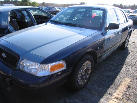 2001 Ford Crown Victoria - Two-tone blue 2001 Ford Crown Victoria parked in an outdoor lot with another vehicle nearby.
