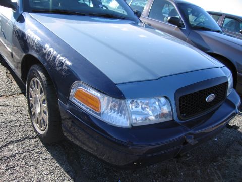 2001 Ford Crown Victoria - Front view of a 2001 Ford Crown Victoria police car showing the fender, grille, and headlight.