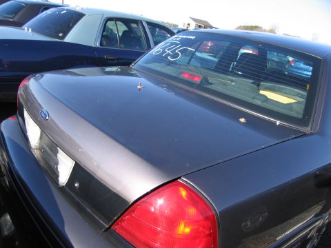 2001 Ford Crown Victoria - A dark gray 2001 Ford Crown Victoria is seen from the rear, with the number '645' written on its back window.