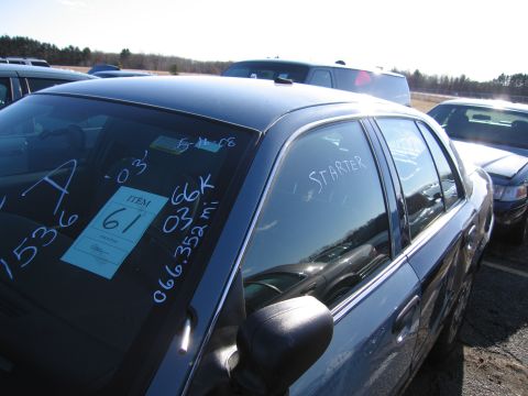 2001 Ford Crown Victoria - Auction lot with a dark blue sedan, showing various handwritten notes on the glass.