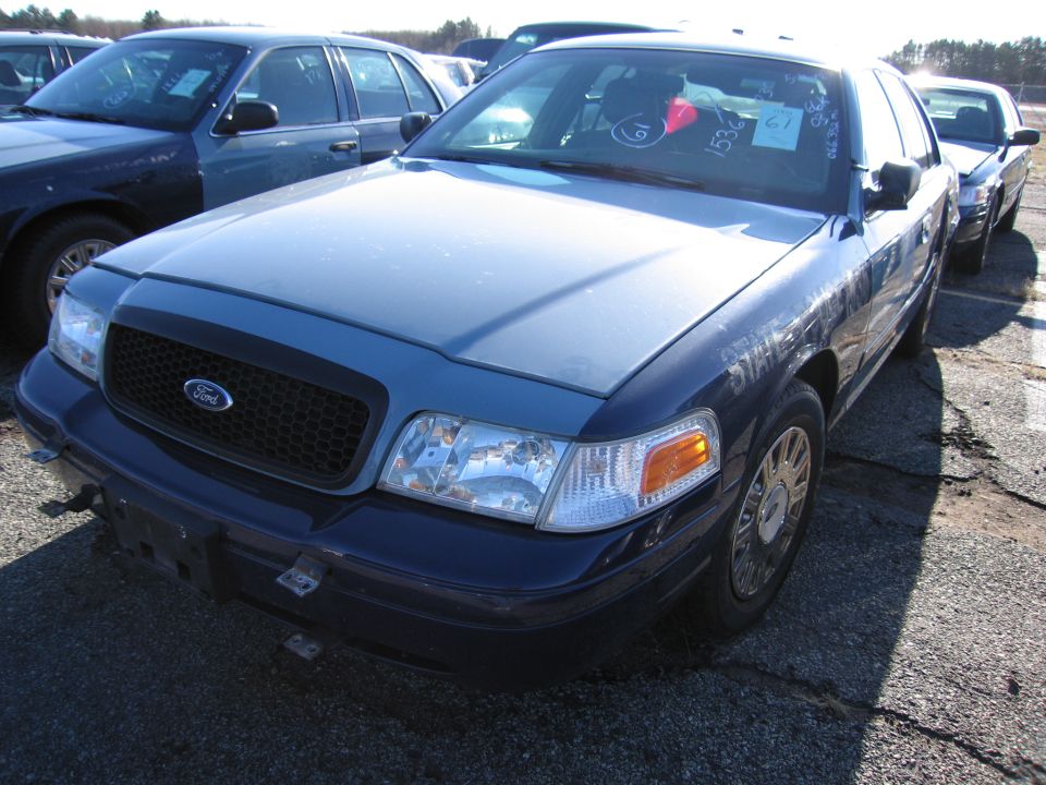 Blue 2001 Ford Crown Victoria front 3/4 view. Visible VIN tags on windshield