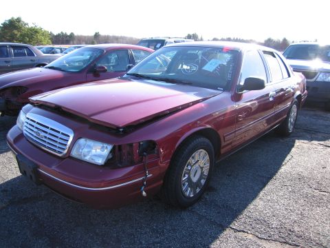 2001 Ford Crown Victoria - Maroon 2001 Ford Crown Victoria in a car lot, hood up and front damage visible.