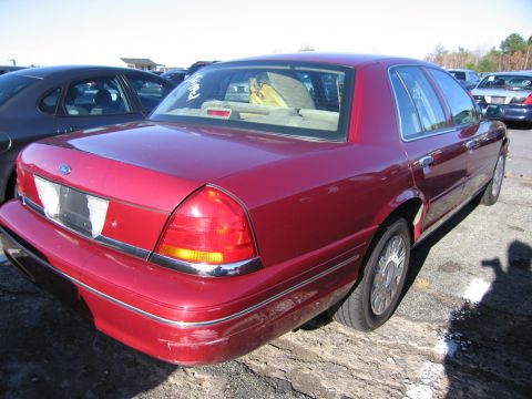 2001 Ford Crown Victoria - Rear view of a red 2001 Ford Crown Victoria sedan parked on a lot.