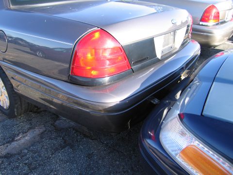 2001 Ford Crown Victoria - Rear view of a gray 2001 Ford Crown Victoria, showing its taillight and bumper detail.