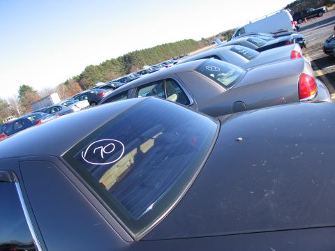 2001 Ford Crown Victoria - A dark sedan's rear window displays a circled number 70, with many other vehicles visible in the background.