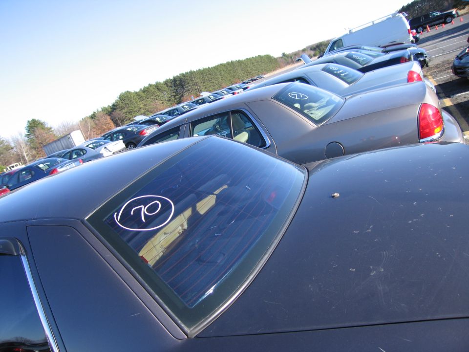 Dark sedan rear window with circled 70; multiple cars in lot