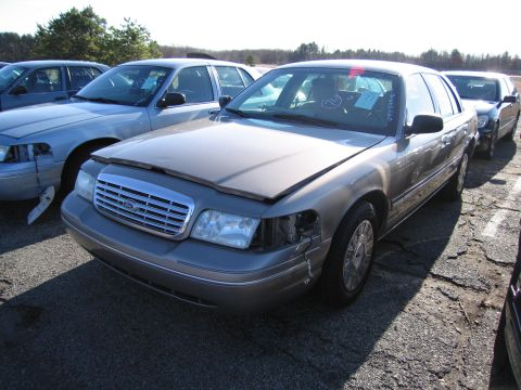 2001 Ford Crown Victoria - Front view of a 2001 Ford Crown Victoria with its hood open and damaged headlight.
