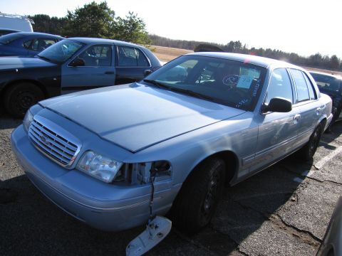 2001 Ford Crown Victoria - Light blue 2001 Ford Crown Victoria sedan parked outdoors with another vehicle nearby.