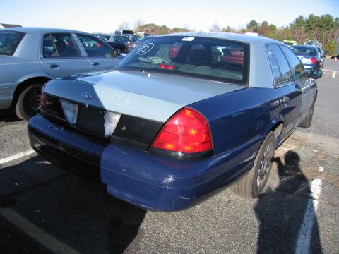 2001 Ford Crown Victoria - Rear view of a blue and grey 2001 Ford Crown Victoria in an outdoor lot.