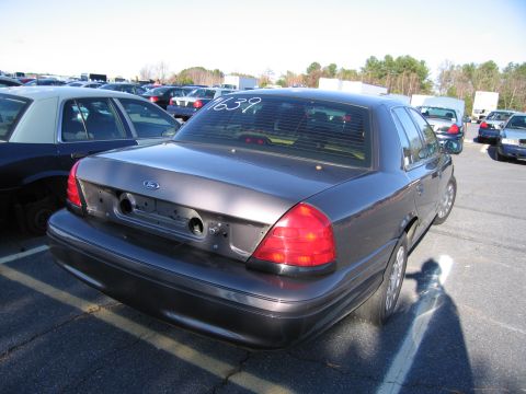 2001 Ford Crown Victoria - Rear view of a 2001 Ford Crown Victoria parked in an outdoor lot with other vehicles.