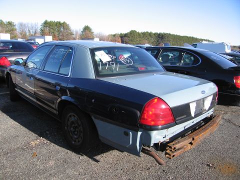 2001 Ford Crown Victoria - Rear view of a 2001 Ford Crown Victoria with two-tone paint and a missing bumper.