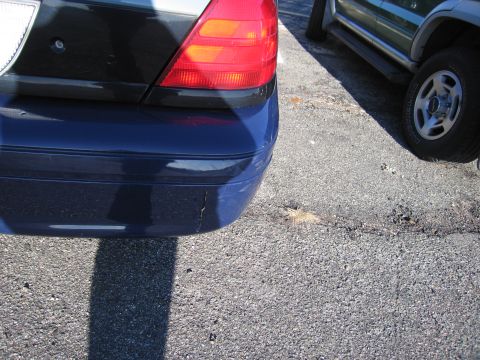 2001 Ford Crown Victoria - Rear view of a dark blue sedan next to a silver SUV.