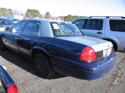2001 Ford Crown Victoria - A 2001 Ford Crown Victoria sedan is seen from the rear quarter angle, with numbers written on the windows.